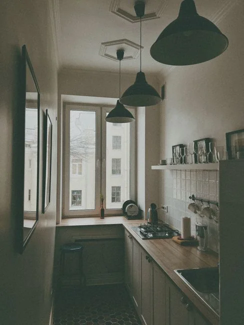 A couple wrapping furniture in a bright apartment, preparing to move.